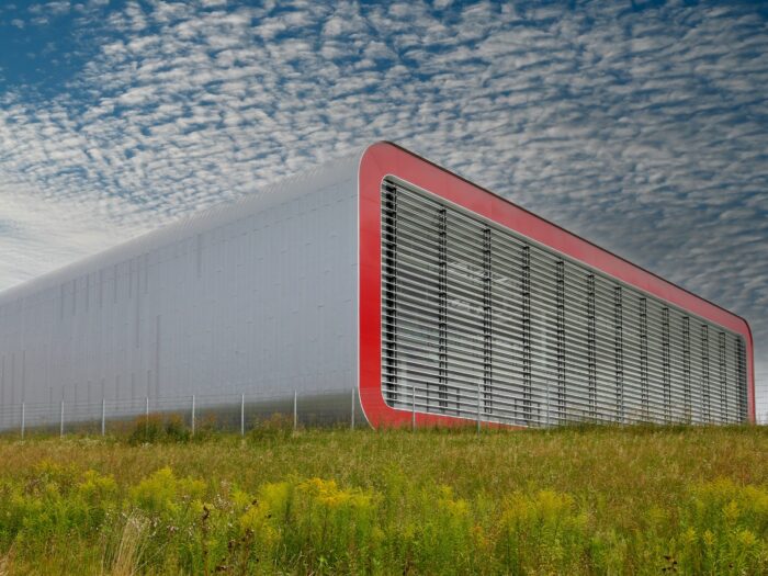 Stehfalzfassade aus geprägtem HFX Edelstahl von ROOFINOX. Vorgefertigte gerundete Fassadenelemente von V-MET. großflächige Fassadenverkleidung.